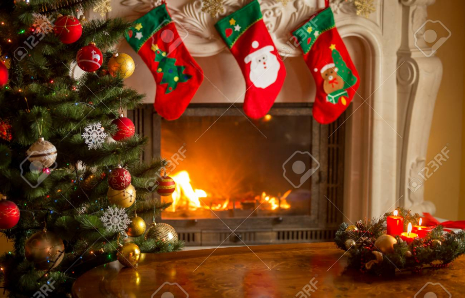 Empty wooden table in front of decorated fireplace and Christmas tree. Place for text.